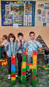 Uczniowie z wykonanymi z klocków literami