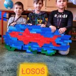 Uczniowie z ukończoną rybą wykonaną z klocków