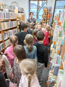 Pani prezentująca księgozbiór uczniom