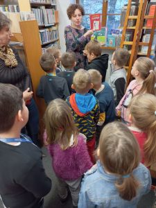 Pani prezentująca księgozbiór uczniom