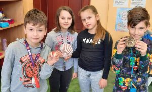 Grupa uczniów pokazujące muszle