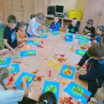 Dzieci przyklejające elementy na kartkę