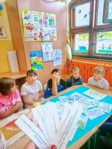 Dzieci dostające karteczki z hasłami