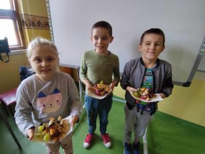 DZieci prezentujące przekąski przygotowane z owoców