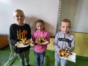 DZieci prezentujące przekąski przygotowane z owoców
