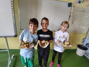 DZieci prezentujące przekąski przygotowane z owoców