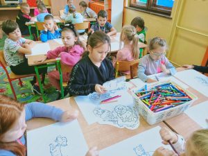 Grupa dzieci kolorująca obrazki ze zwierzętami