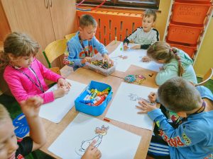 Grupa dzieci kolorująca obrazki ze zwierzętami