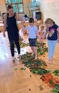 chłopiec idący po ścieżce z liści, kasztanów żołędzi