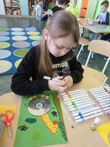 Uczniowie wykonują prace plastyczno techniczną "Zwierzątka" wykorzystując płyty CD