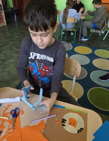 Uczniowie wykonują prace plastyczno techniczną "Zwierzątka" wykorzystując płyty CD