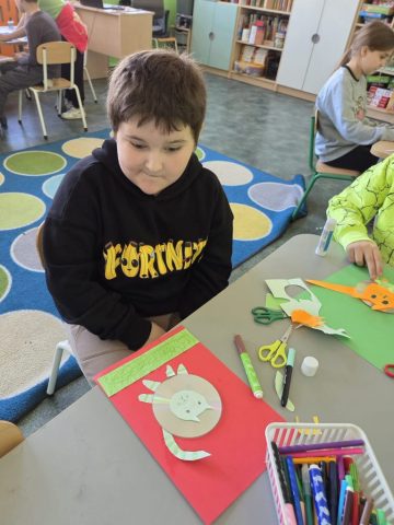 Uczniowie wykonują prace plastyczno techniczną "Zwierzątka" wykorzystując płyty CD