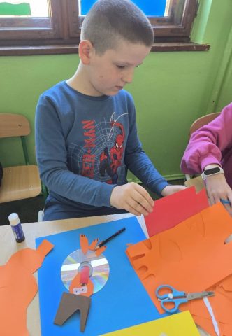 Uczniowie wykonują prace plastyczno techniczną "Zwierzątka" wykorzystując płyty CD